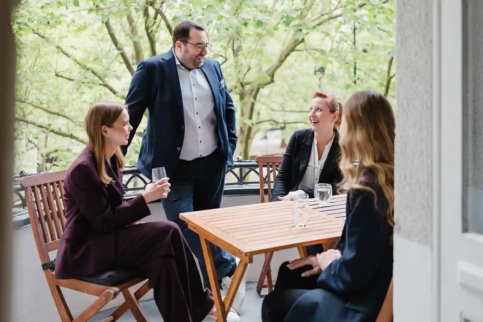 R.TAX Team im entspannten Austausch auf dem Kanzlei-Balkon im Herzen von Berlin