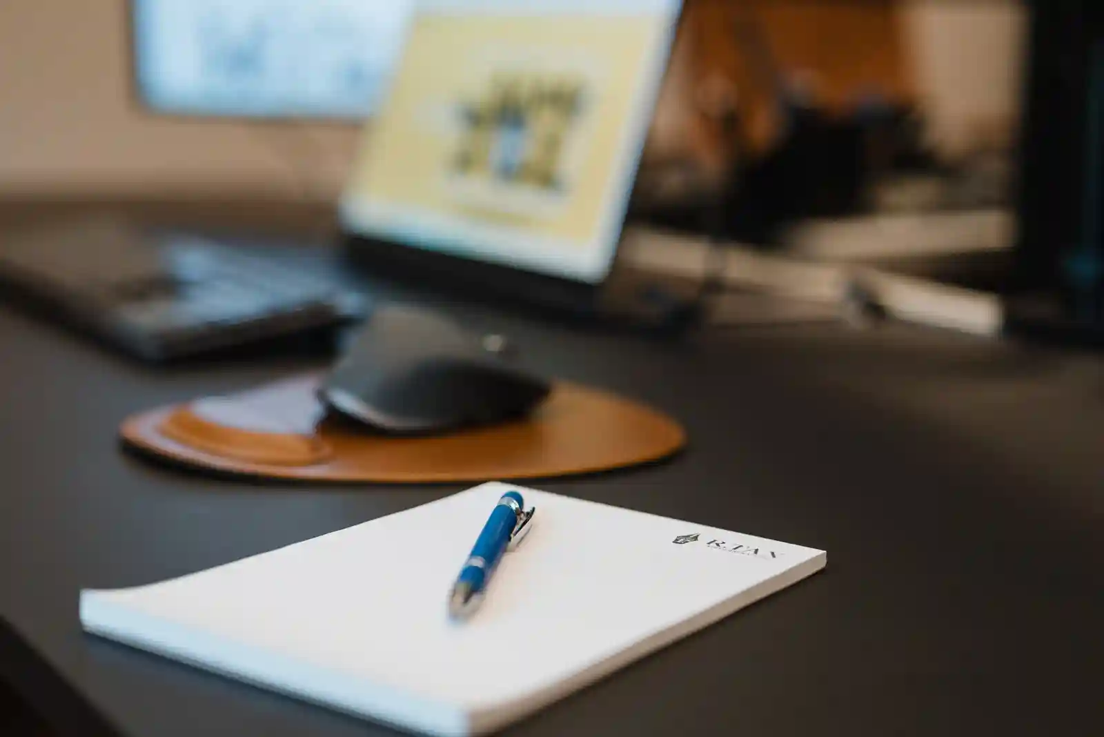 R.TAX Notizblock mit Stift auf modernem Schreibtisch in Berliner Steuerkanzlei für digitales Arbeiten