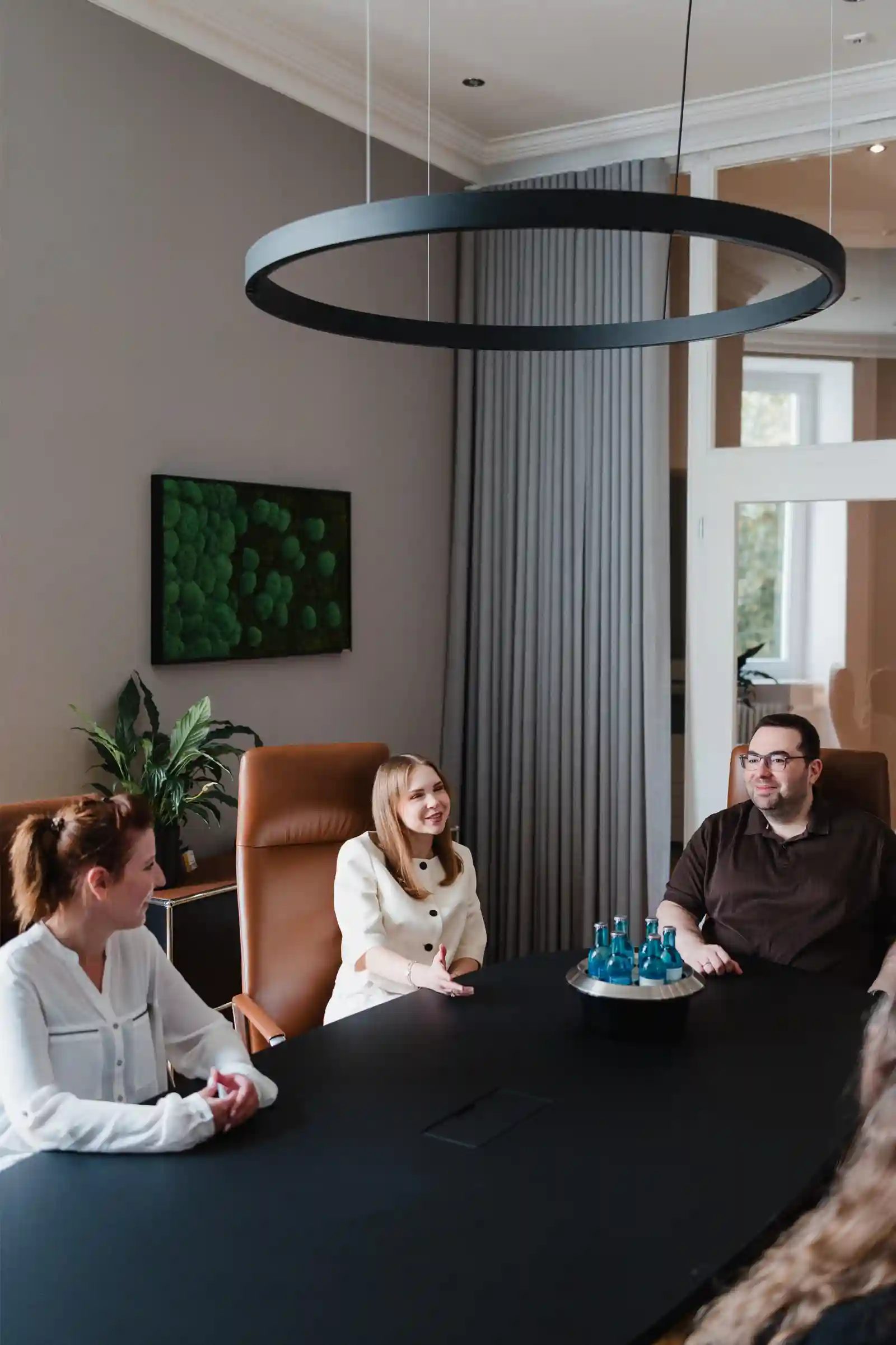 Moderner Konferenzraum bei R.TAX Steuerberatung mit Team in Besprechung und Berliner Altbau-Elementen