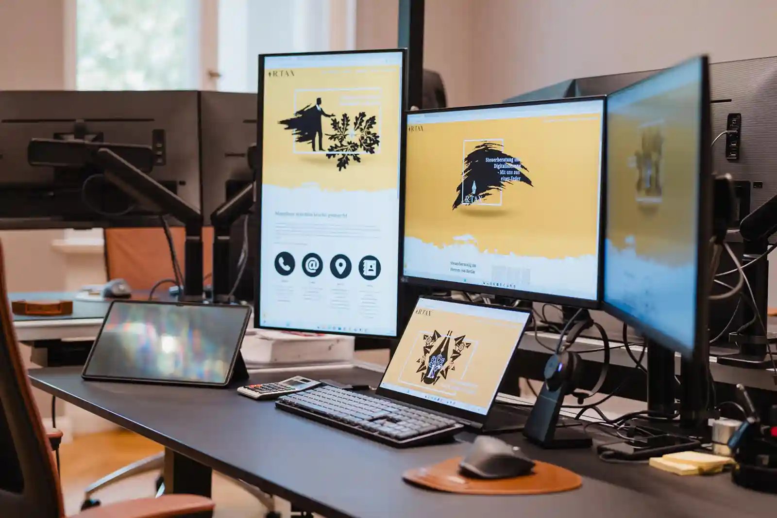 Ergonomischer Schreibtisch in der Berliner Steuerkanzlei R.TAX mit Multi-Monitor-Setup für digitales Arbeiten
